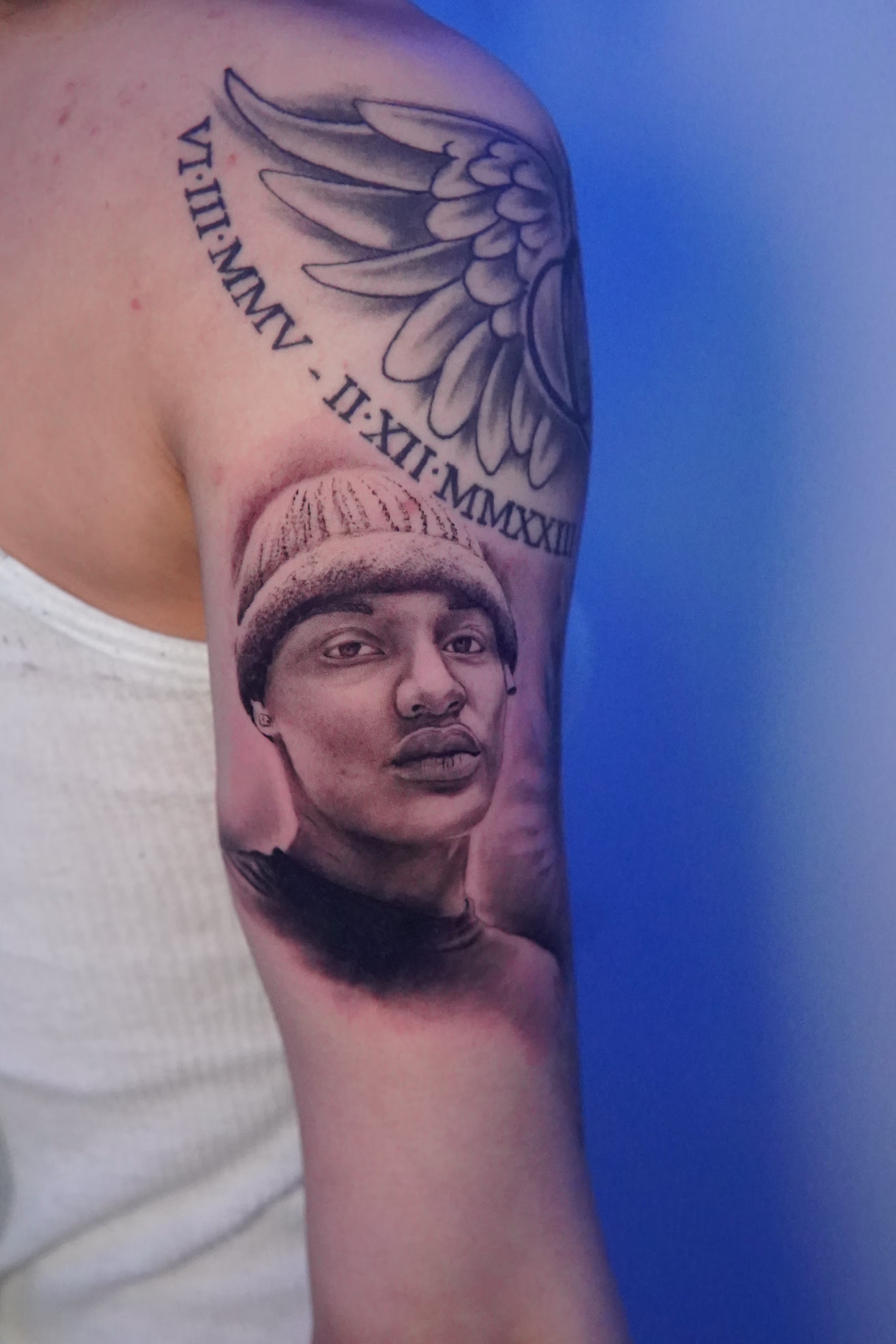Portrait of a loved one with a beanie on the right bicep.