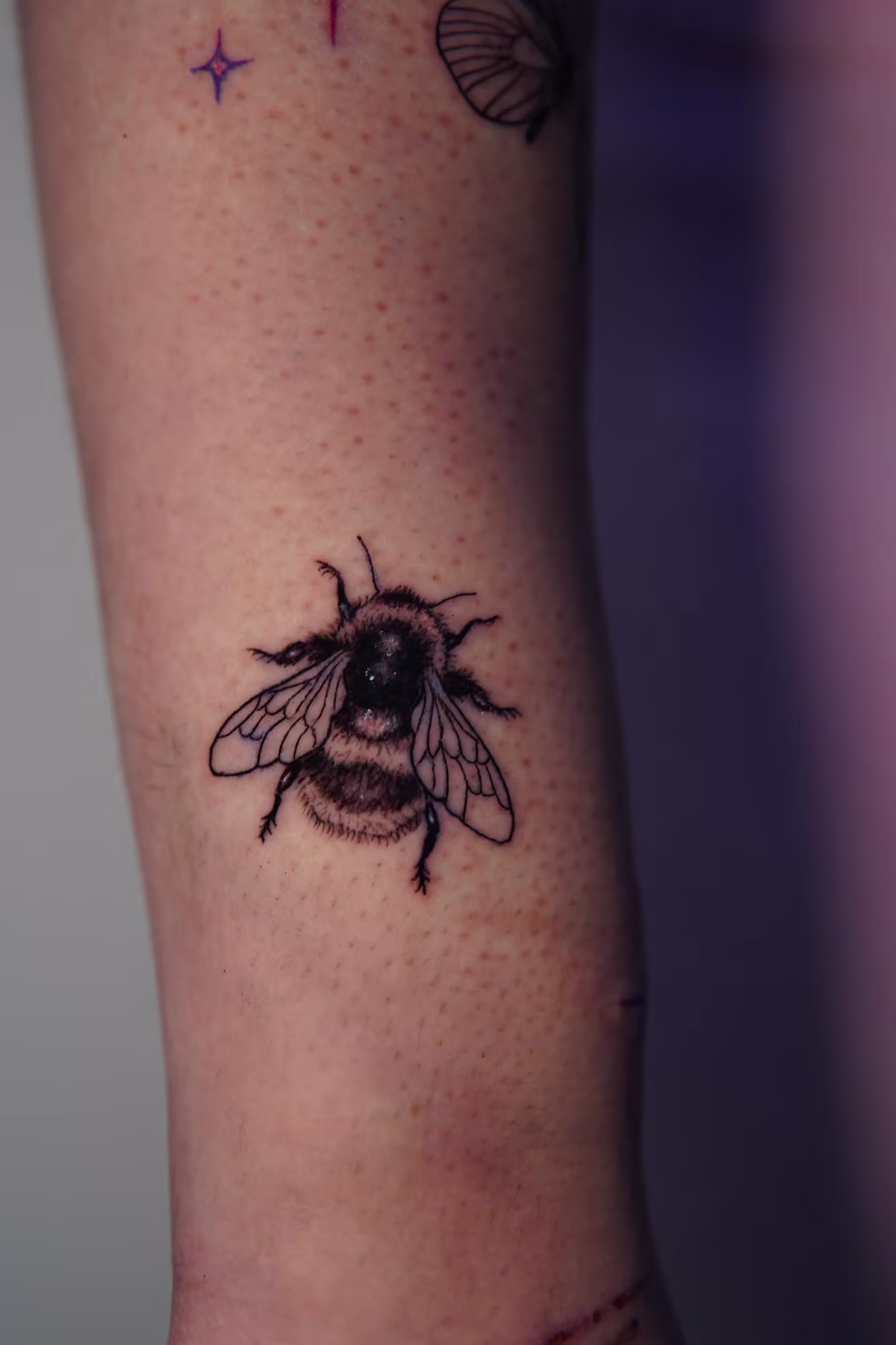 Fuzzy 2-inch bee on the top of the forearm.
